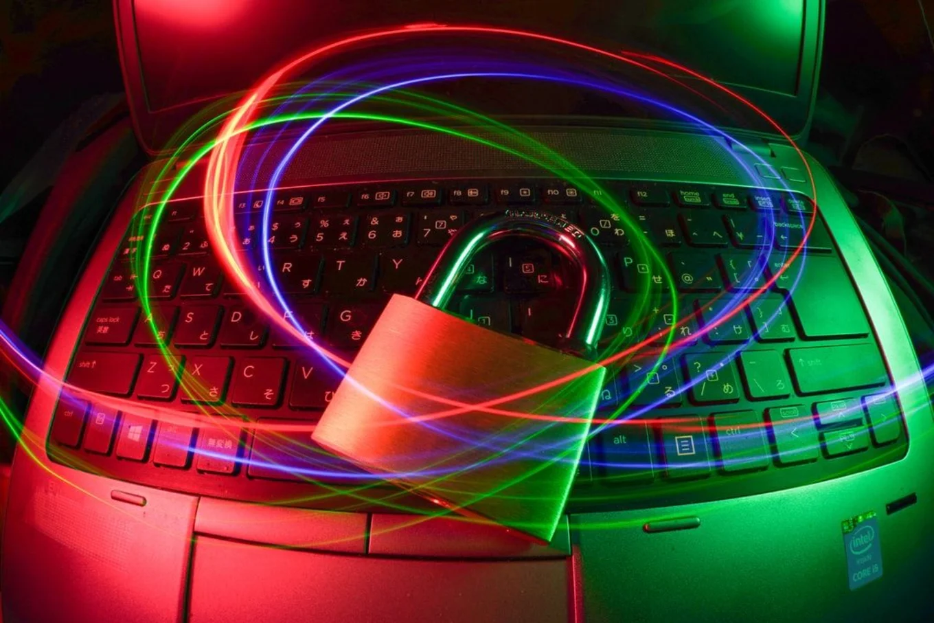 Lock on laptop keyboard with colorful light trails.